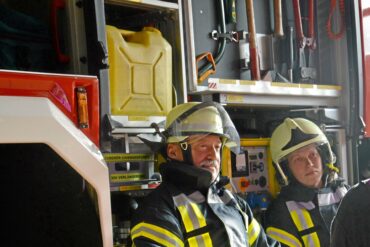 Zwei Feuerwehrleute nach einem schlimmen Einsatz – ein Peer des Einsatznachsorge-Teams der Kreisfeuerwehr kümmert sich um die beiden.