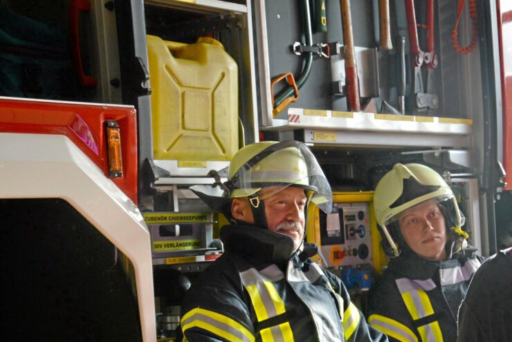 Zwei Feuerwehrleute nach einem schlimmen Einsatz – ein Peer des Einsatznachsorge-Teams der Kreisfeuerwehr kümmert sich um die beiden.
